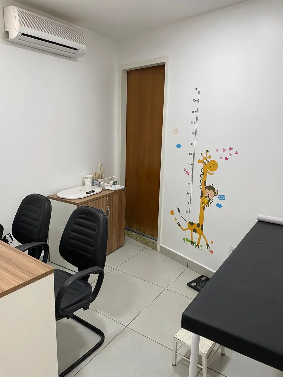 Consultório de pediatria com régua de crescimento na parede